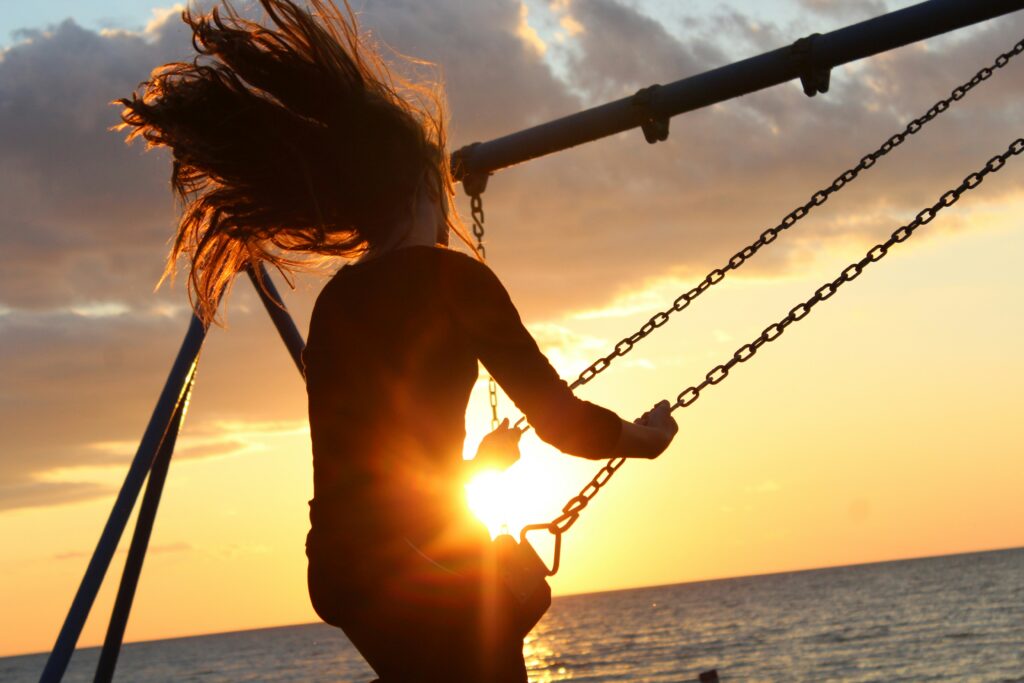 Woman on swing at sunset